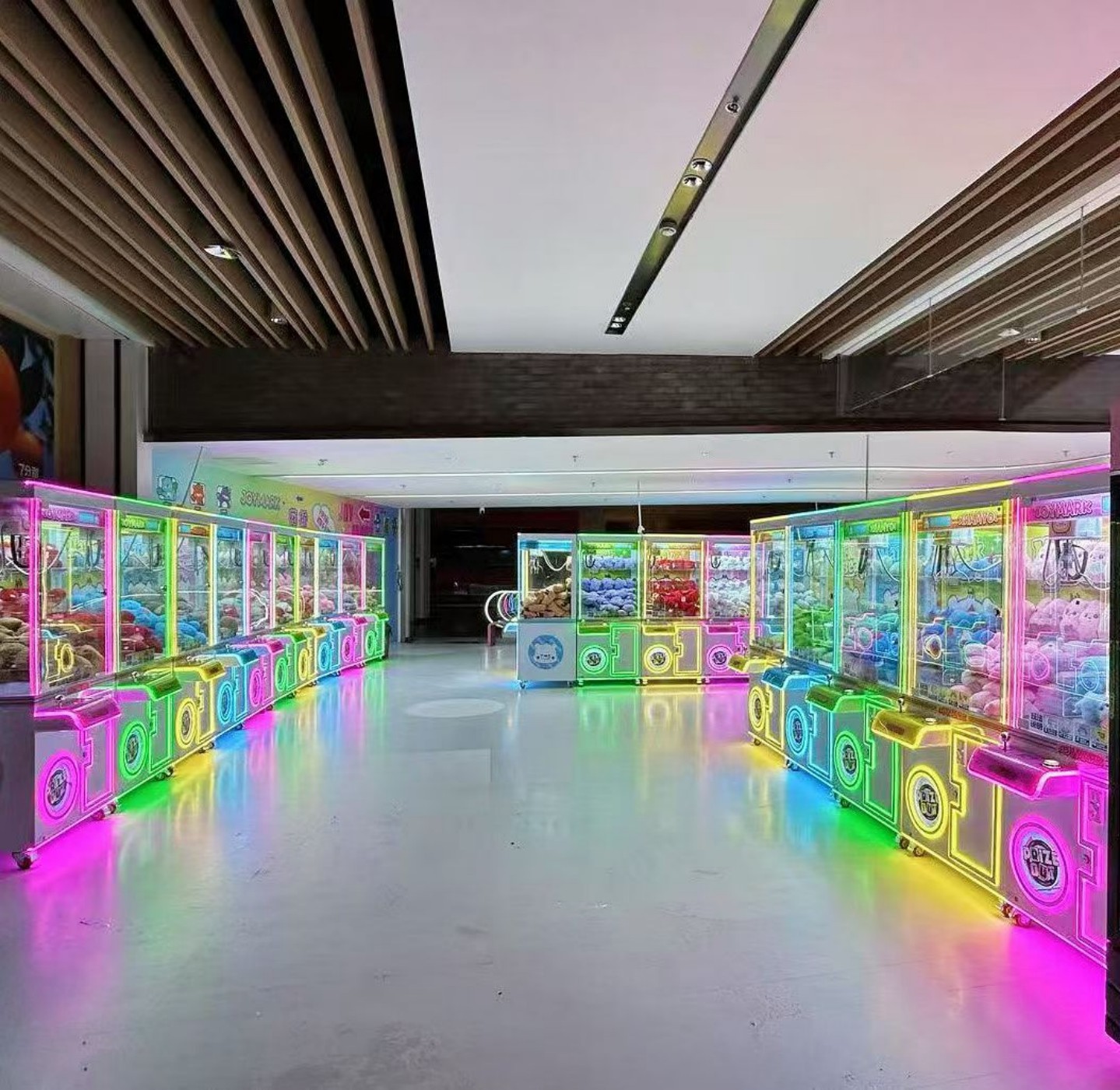 Personal mini claw machines with colorful LED lighting arranged in a spacious entertainment environment