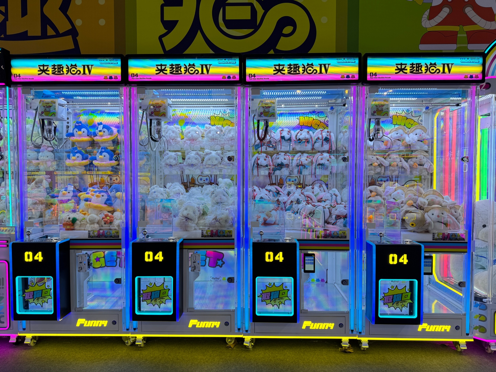 Chengjietian Gen 4 claw machines lineup with full transparent acrylic cabinet and RGB LED lighting in arcade environment