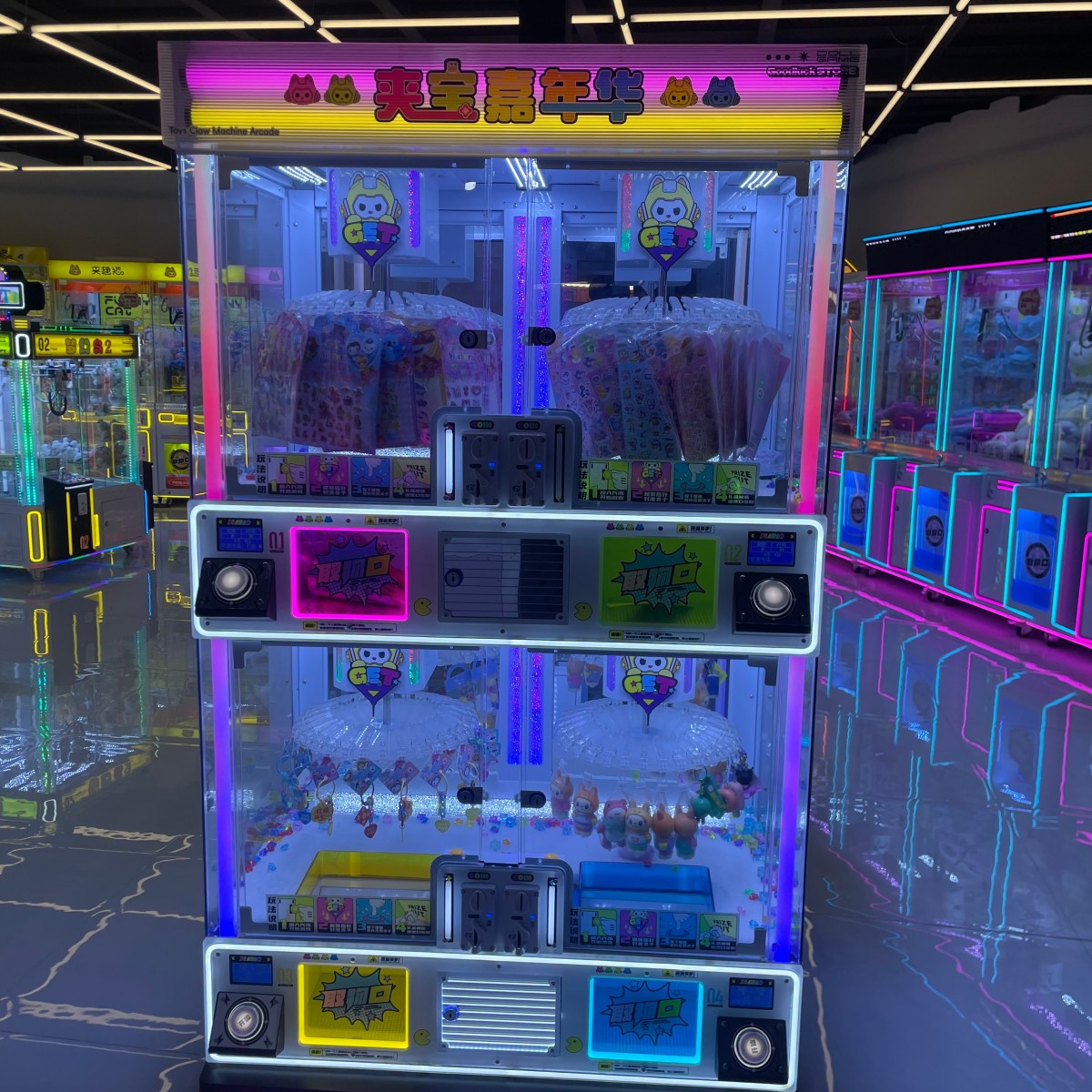 Four-player clip prize machine installed in modern arcade with colorful LED lighting and multiple prize zones