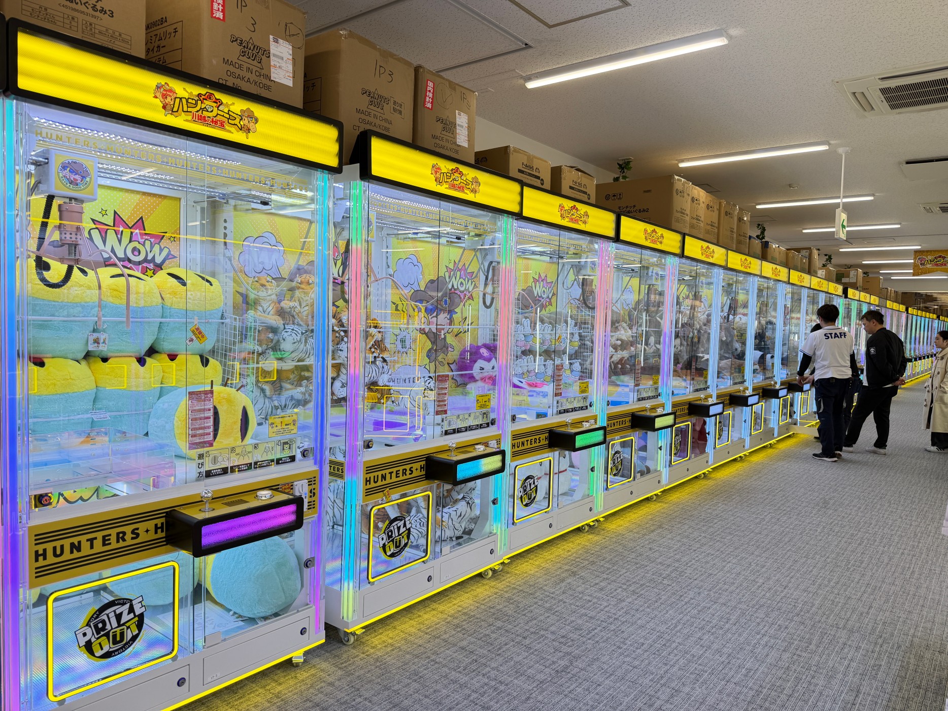 Multiple full transparent giant claw machines installed in an arcade, jumbo acrylic claw machines with LED lighting for plush prizes