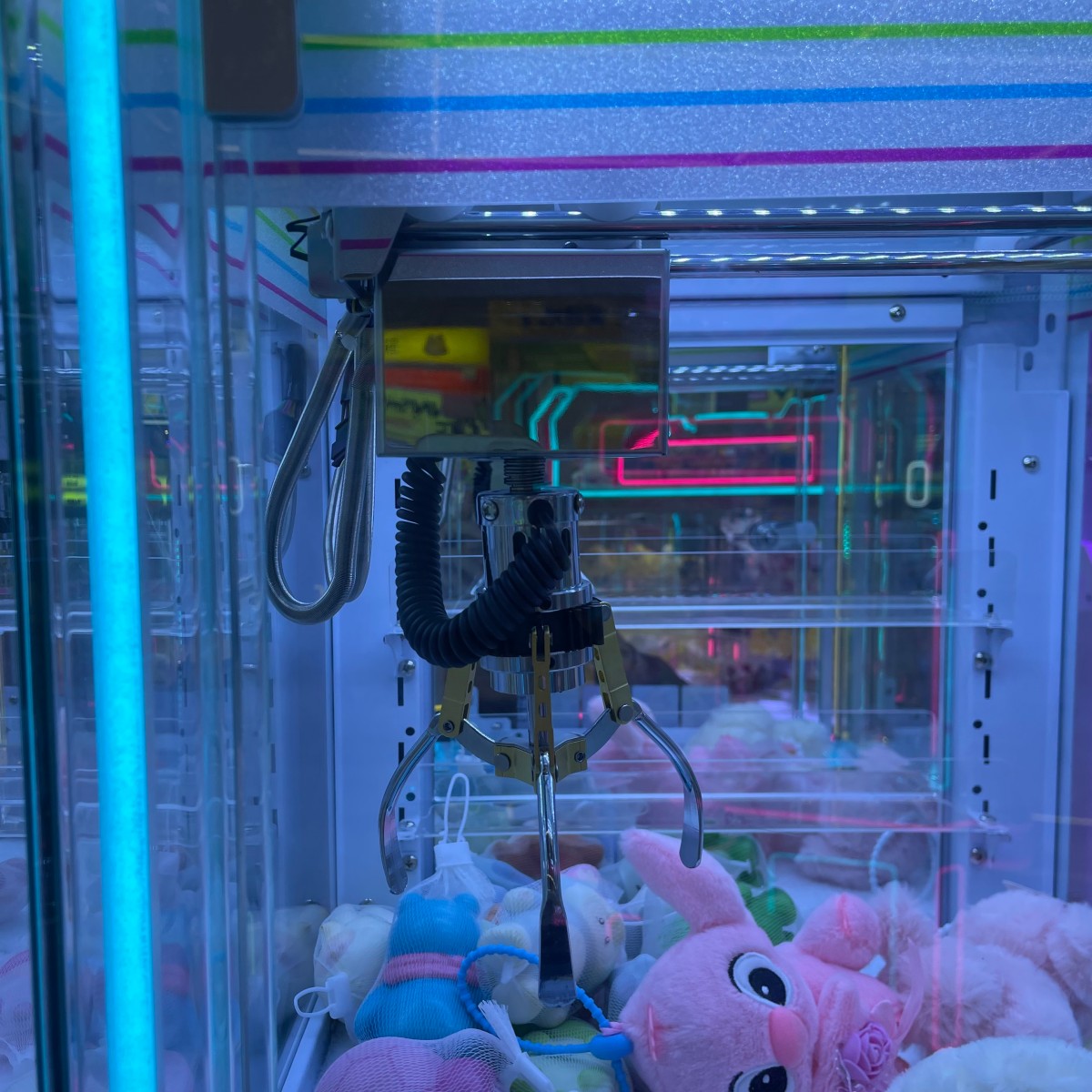 Personal mini claw machine prize outlet and front operation area with colorful LED frame