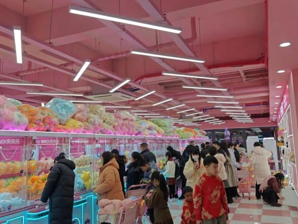 Players enjoying Chengjietian Gen 3 claw machines during gameplay in a busy arcade environment