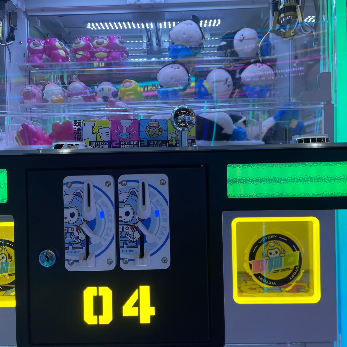 Prize chute and coin entry detail of Gen 4 mini claw machine during successful prize payout