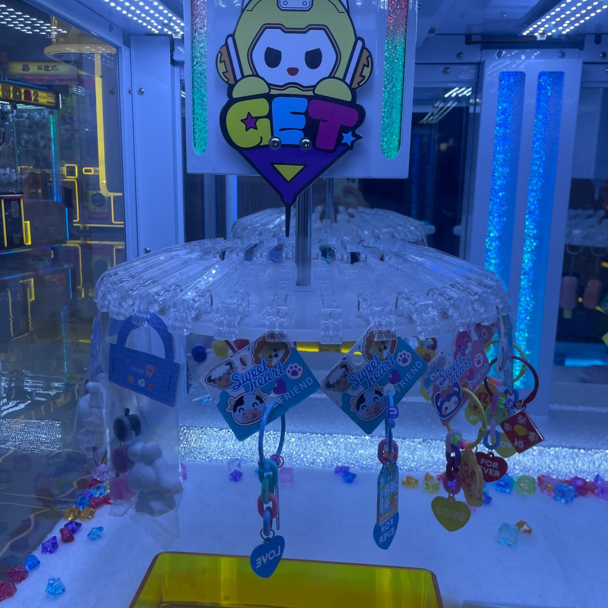 Rotating clip wheel mechanism of 4-player clip prize machine displaying keychains and small gift prizes