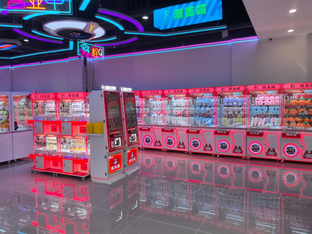 countertop token machine installed in modern arcade with claw machines for self-service token exchange